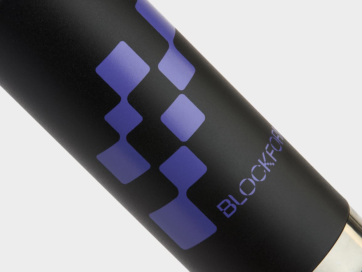 Close-up of a black textured bottle with purple diamond patterns and 'BLOCKFOR' branding.