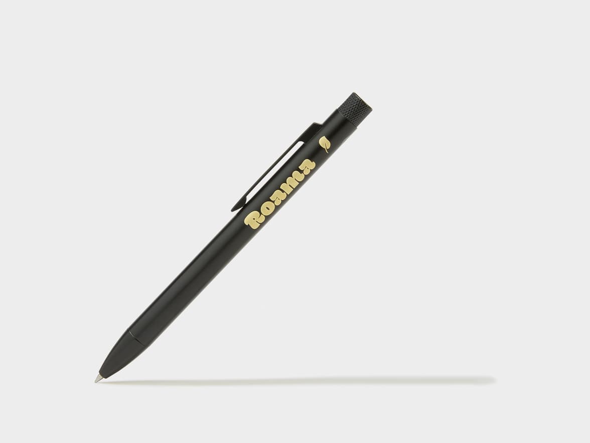A black pen with "Roama" and a leaf symbol written in gold.