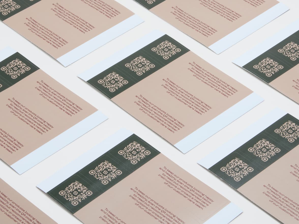A collection of customized rectangular coated stickers with a QR code printed on them.