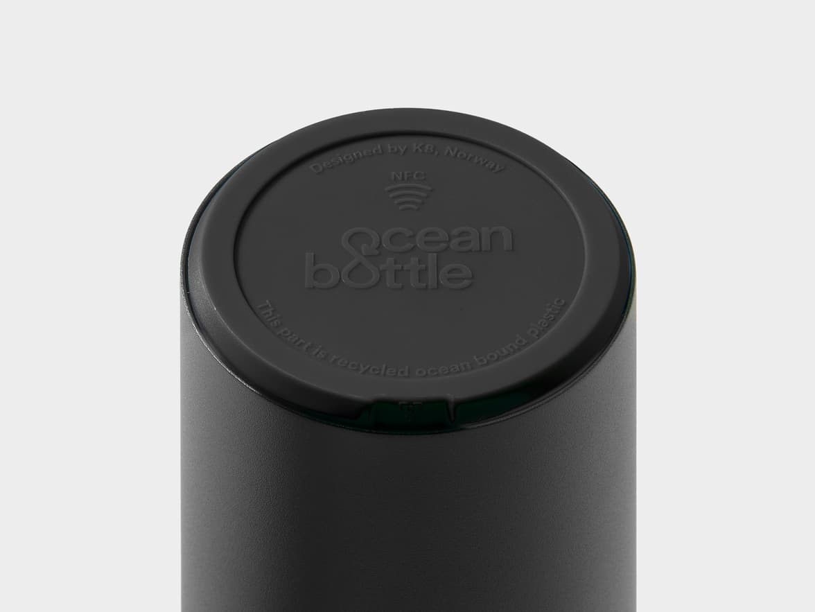 Top of a black "ocean bottle" with text "Designed by K8, Norway", "NFC" symbol, and "This part is recycled ocean bound plastic".