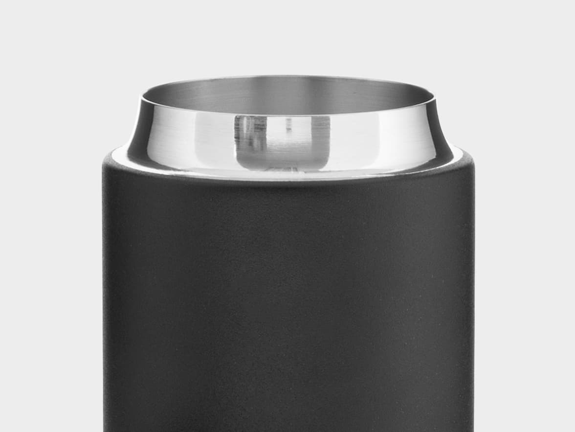 Close-up of the top of a dark, cylindrical insulated bottle or tumbler, showing its matte dark body and a wide, polished stainless steel rim.