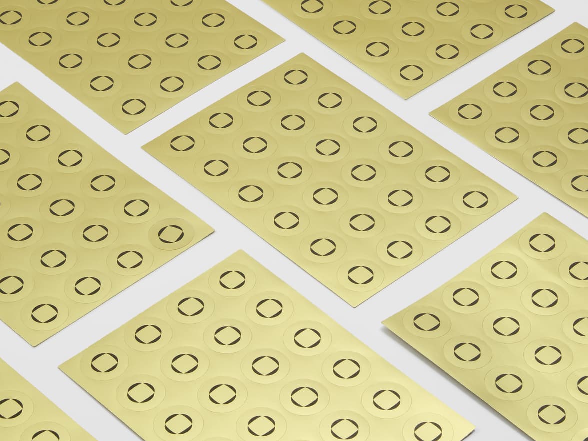 A collection of sheets with round gold metallic stickers.