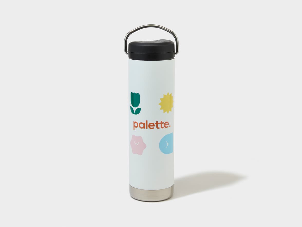 White bottle with black cap, silver handle, and 'palette.' brand name, alongside a green tulip, yellow sun, pink and blue shapes.