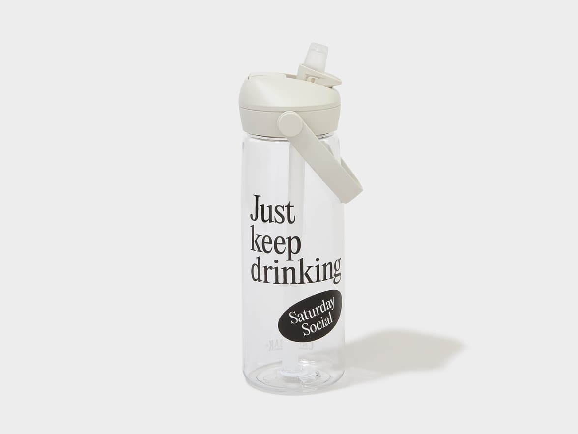 Clear water bottle with a light beige lid and handle, branded with "Just keep drinking" and "Saturday Social".