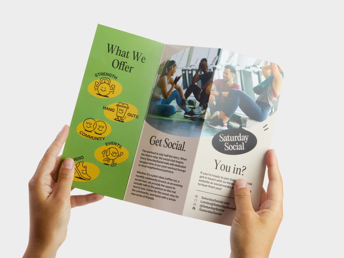 A pair of hands holding open a Z-Fold Original Matte Brochure.