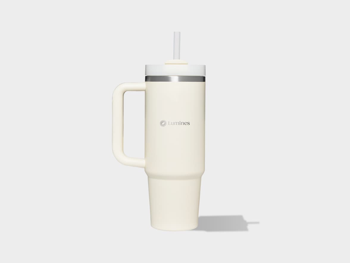 A large, light beige Lumines tumbler with a handle and straw.