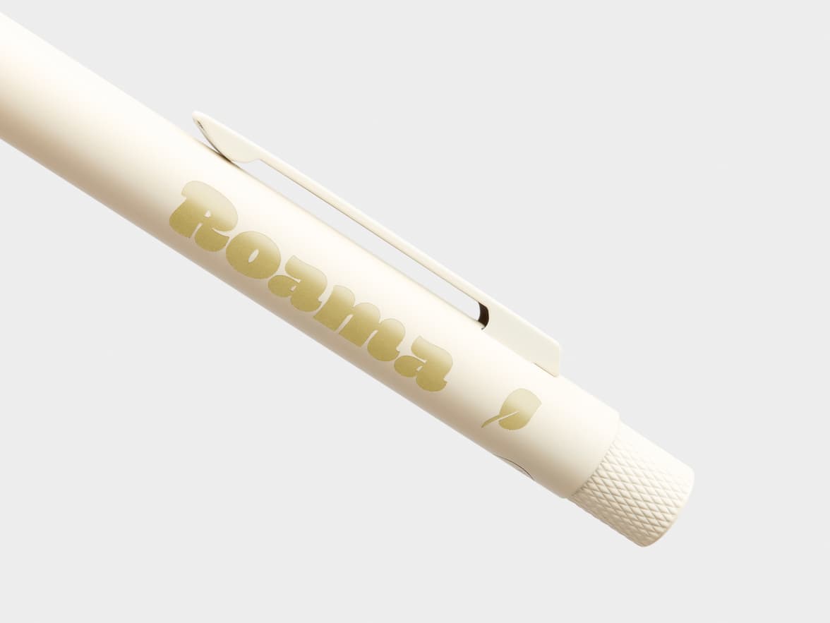 Cream-colored pen with "Roama" branding and a leaf icon.