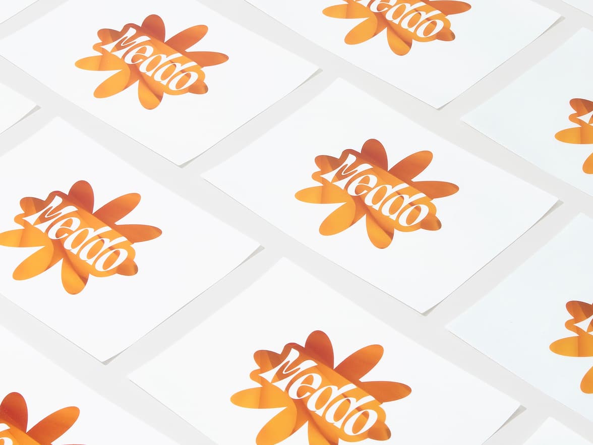 A collection of round clear stickers with a large orange flower printed on it.