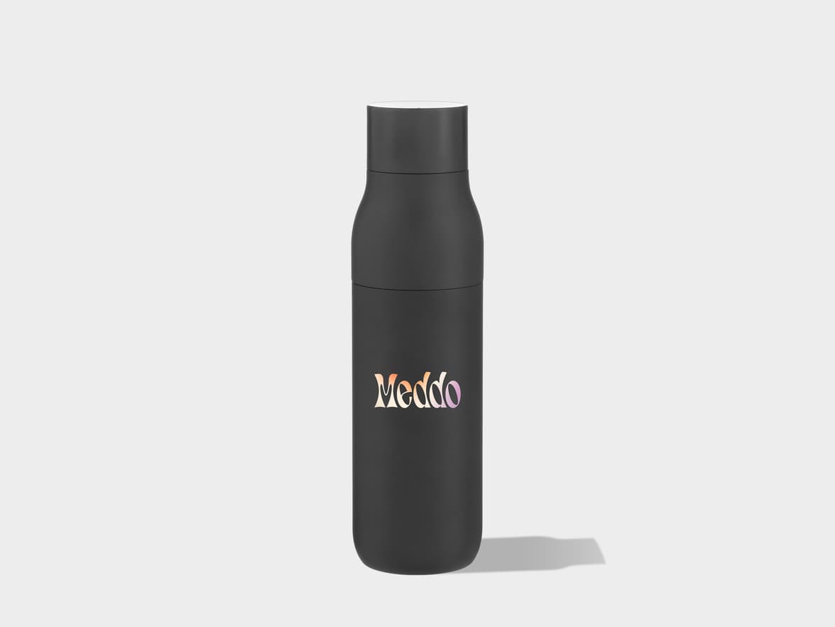 A black water bottle with the word "Meddo" written in a gradient of orange, pink, and purple letters stands upright on a light grey surface, casting a shadow to its right.