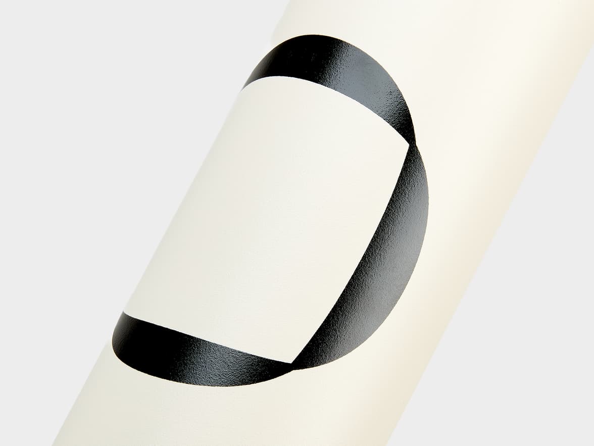 A cream-colored Stanley bottle with a large black abstract design.