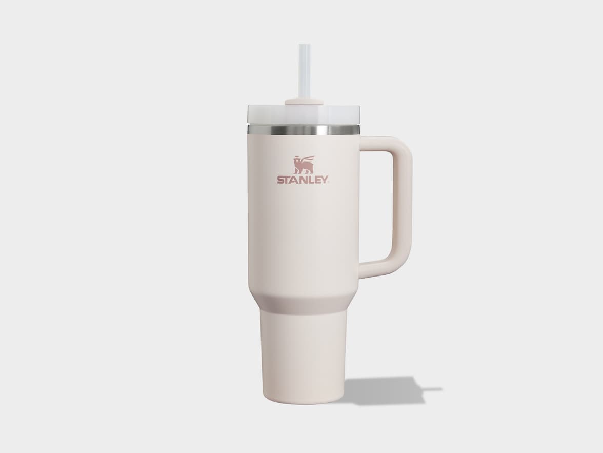 Cream-colored Stanley tumbler with a handle and straw.