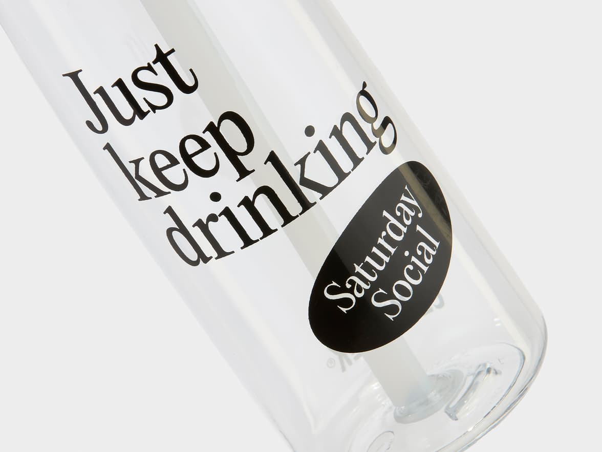 A clear bottle with the text "Just keep drinking" and a "Saturday Social" logo.