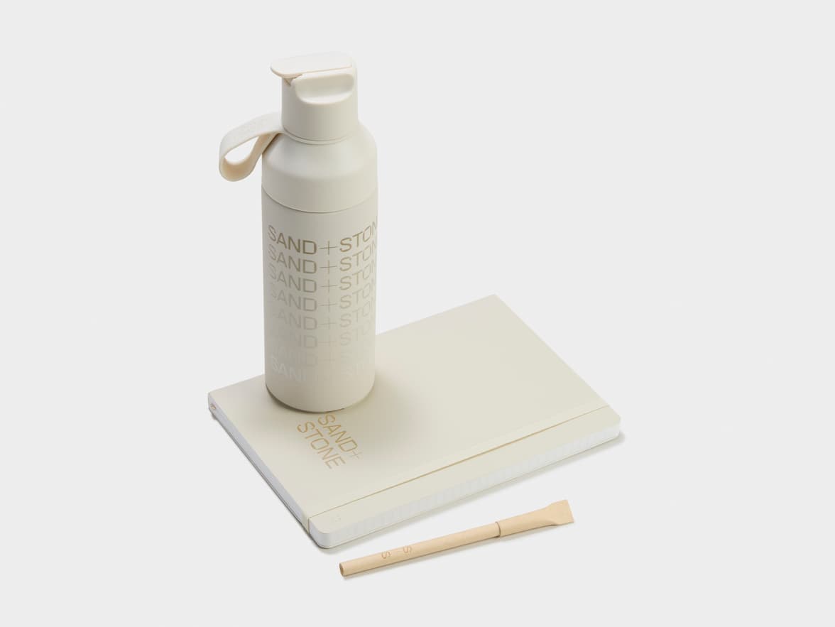 Collection shot of the Karst Stone Paper Softcover Notebooks with a Water bottle and a Pen