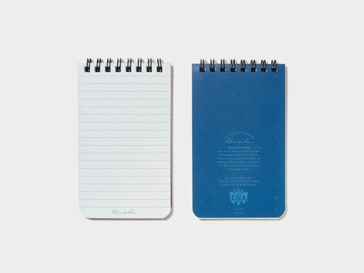 Two Rite in the Rain spiral-bound notebooks, showing the white lined front and the blue back. Both feature "Rite in the Rain" branding, with the back also including product details and a "MADE IN THE USA" logo.