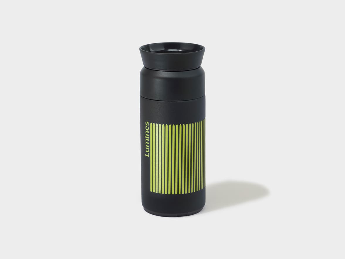 Black travel flask with "Luminés" branding and vertical lime green stripes.
