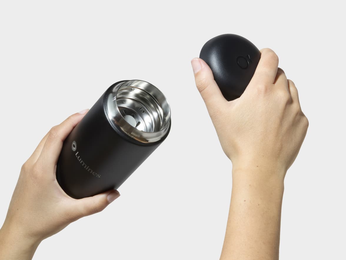 Hands Removing Lid From Matte Black Fellow® Carter Move Mug With One-Sided Engraving