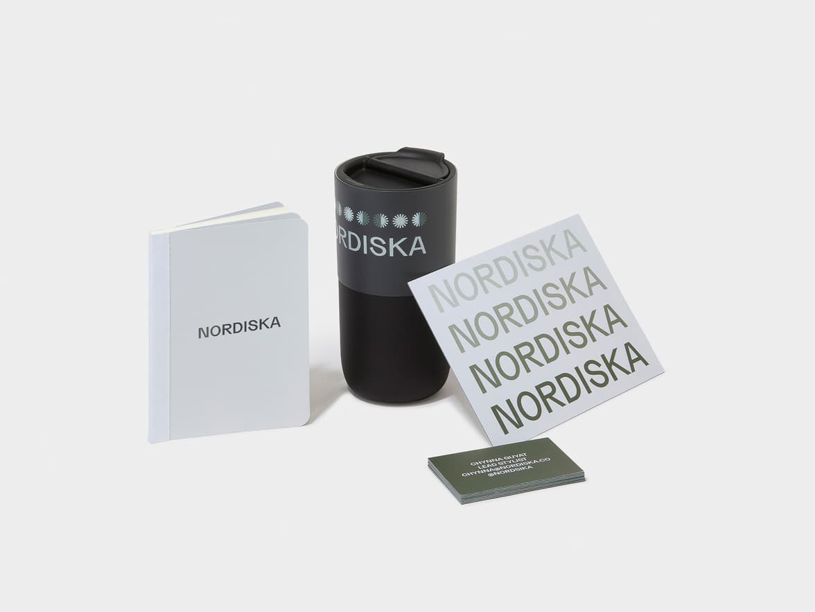 A NORDISKA branding kit featuring a white notebook, a black travel mug, and various cards including one for 'CHYNNA GUYAT LEAD STYLIST' from 'NORDISKA'.