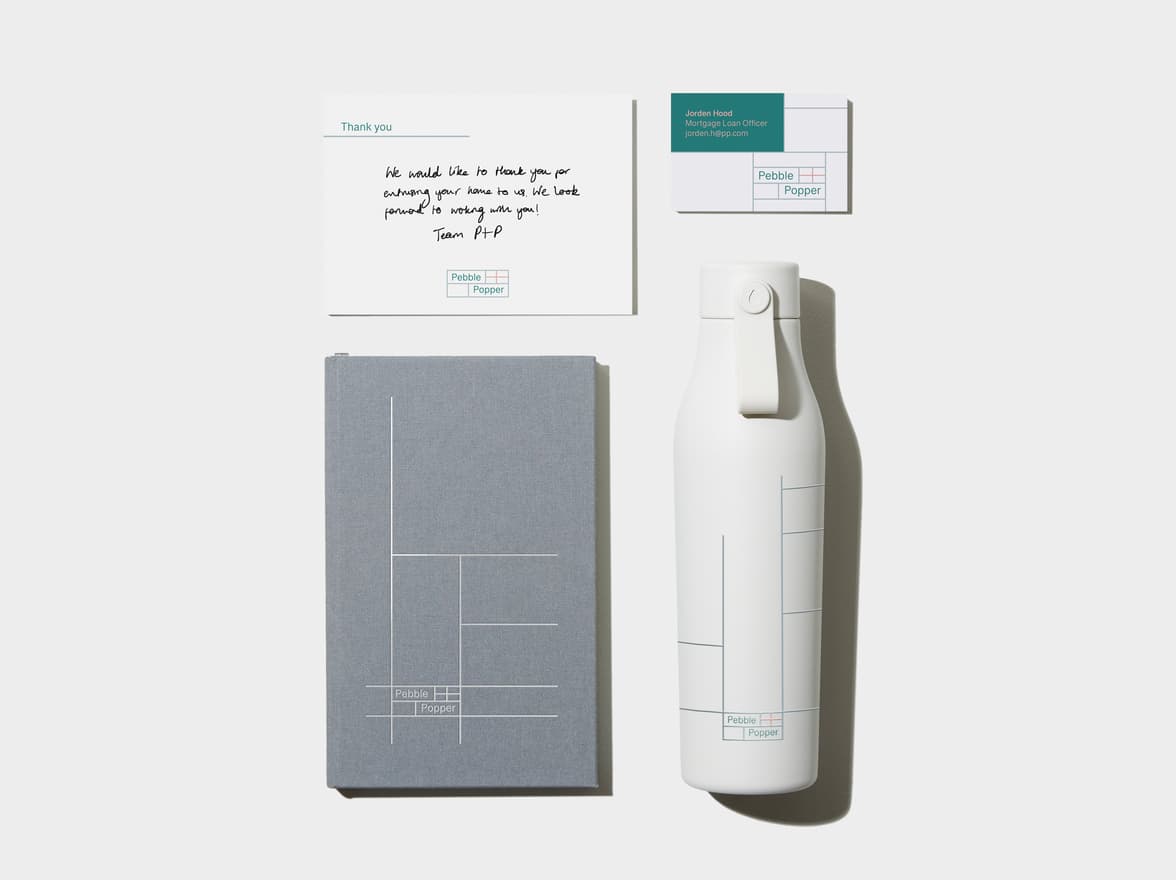 Charcoal Grey flyer in top left corner. Hardcover Notebook with White Foil Pattern in top right corner. A business card with green details in bottom left corner. An Charcoal Grey water bottle with coloured pattern in bottom right corner.  