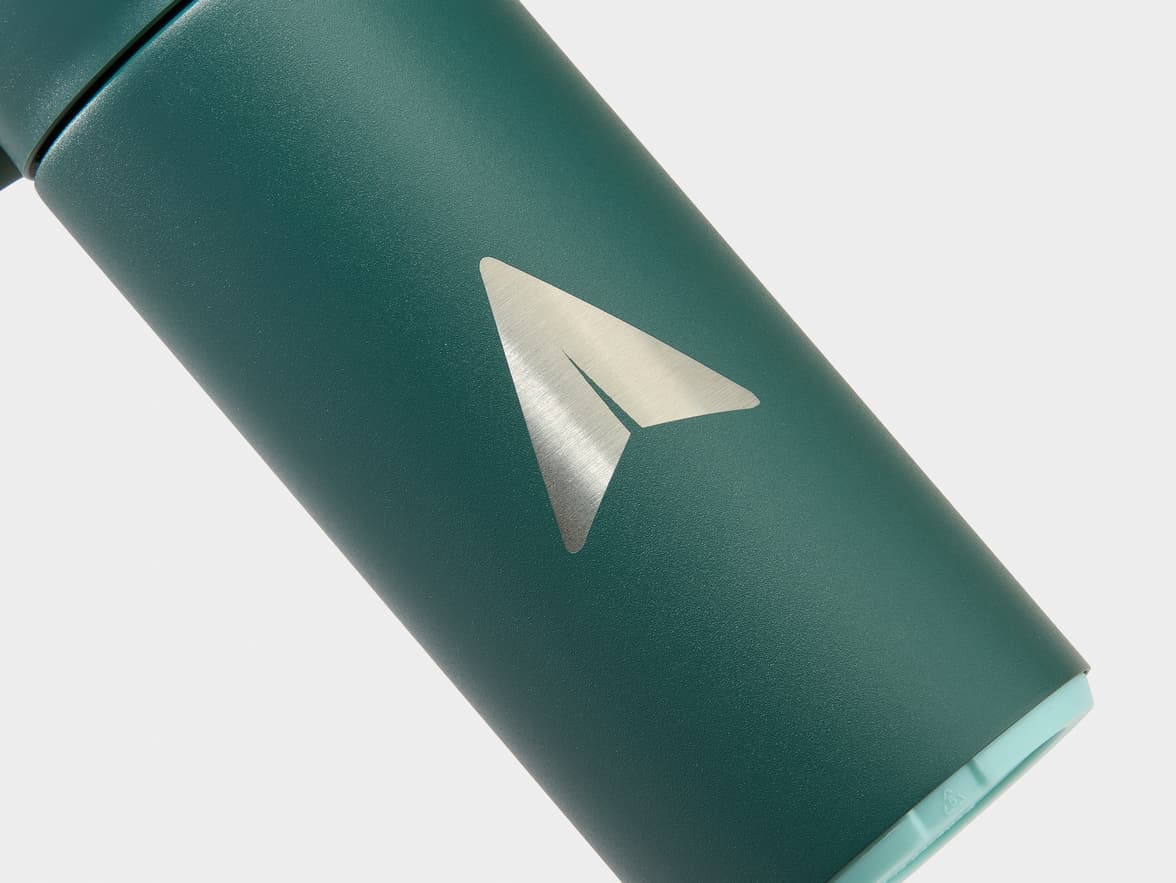 A teal-green insulated bottle with a silver paper airplane logo.