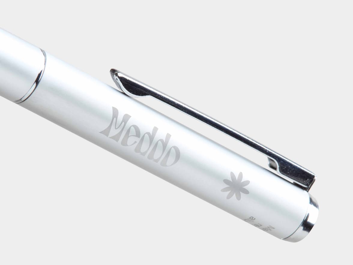 Shiny silver pen with "Meddo" and a flower logo engraved on its barrel.