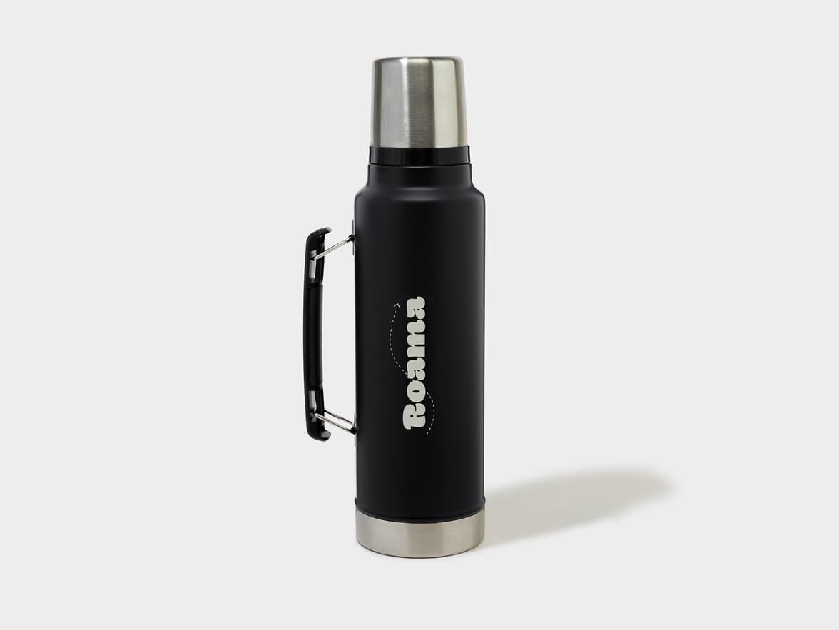 Black thermos with a silver top and bottom, featuring a black handle and "Roama" branding on the side.