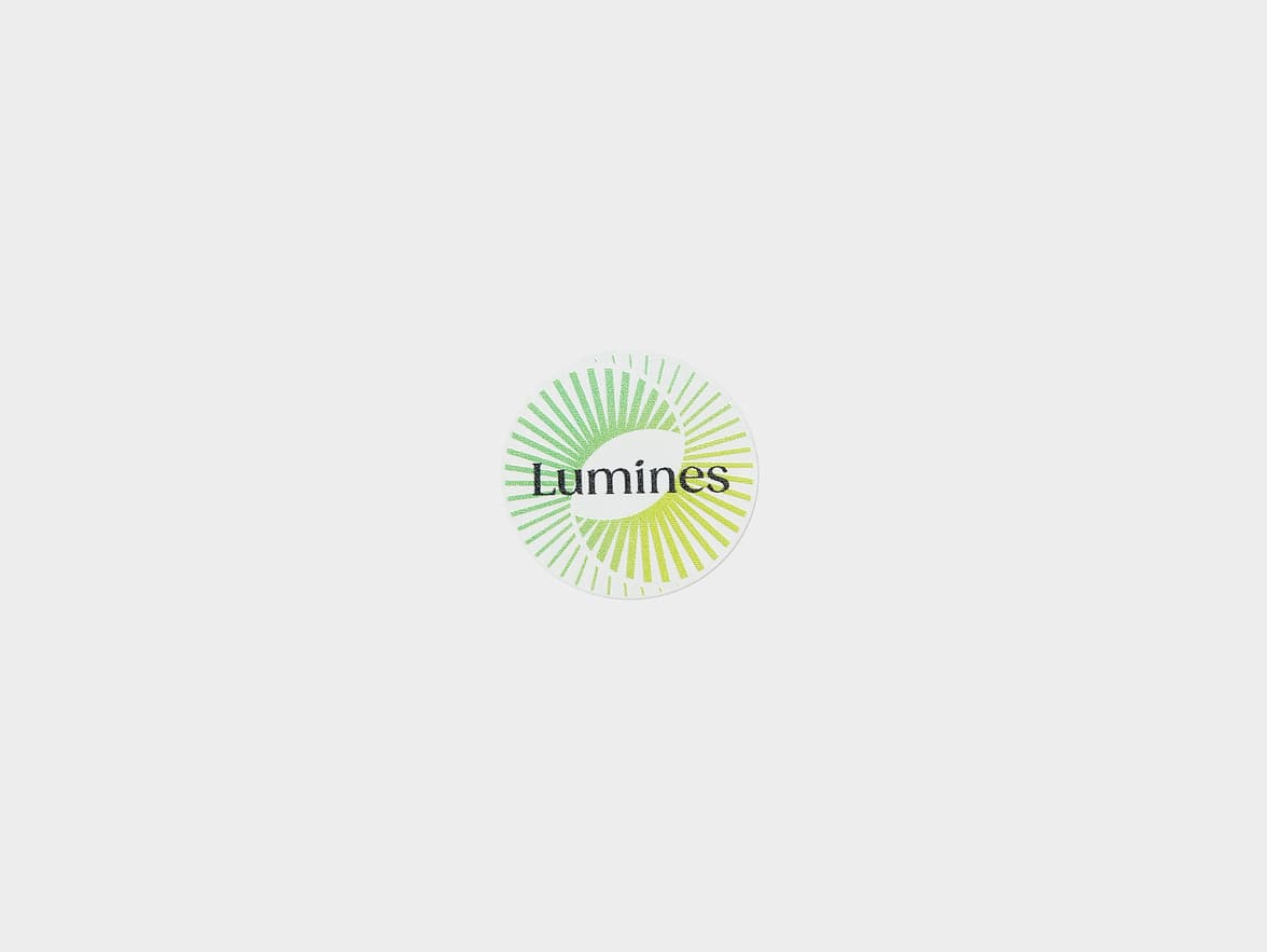 A customized clear round sticker with a light green spiral circle and the word 'Lumines' printed on it.