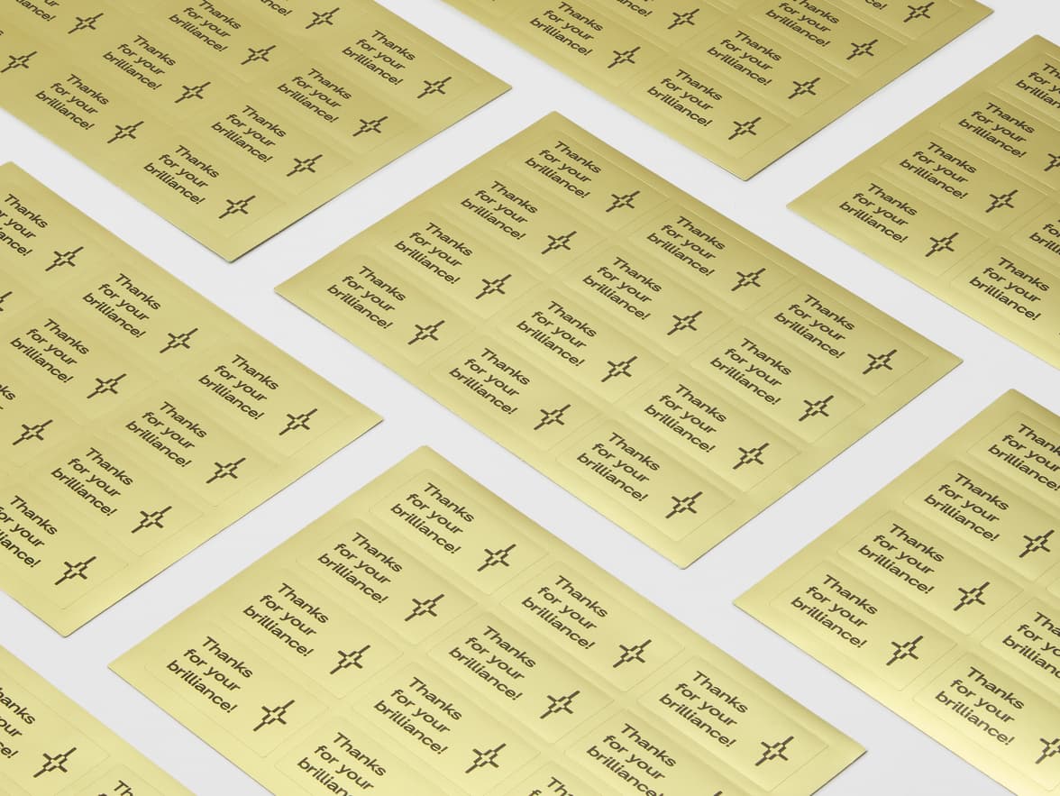 A collection of gold metallic stickers with black customization on sheets.