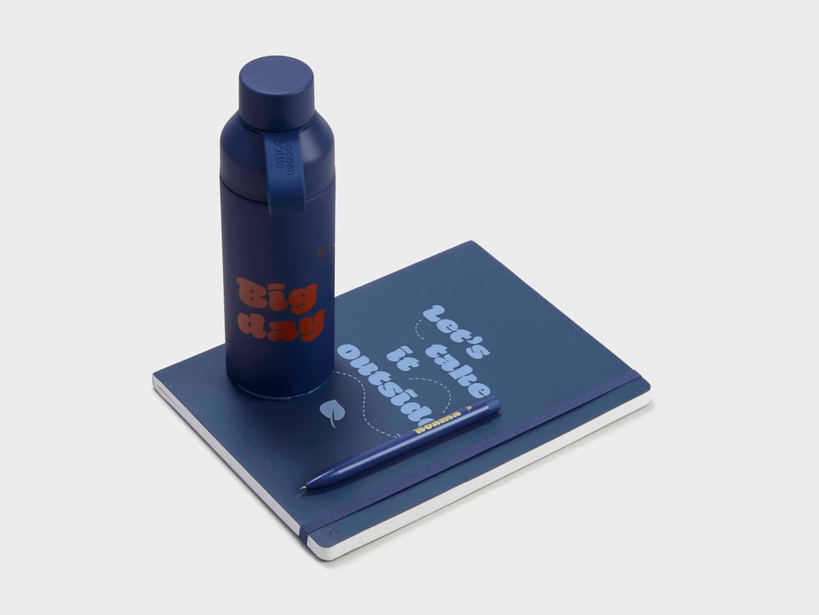 Collection shot of the Navy Karst Stone Paper Pro Series Softcover Notebook with a Water Bottle and a Pen