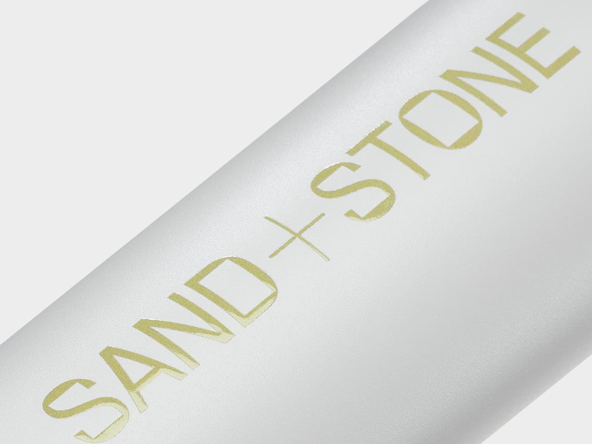 Detailed image of cloud grey water bottle with custom gold branding.