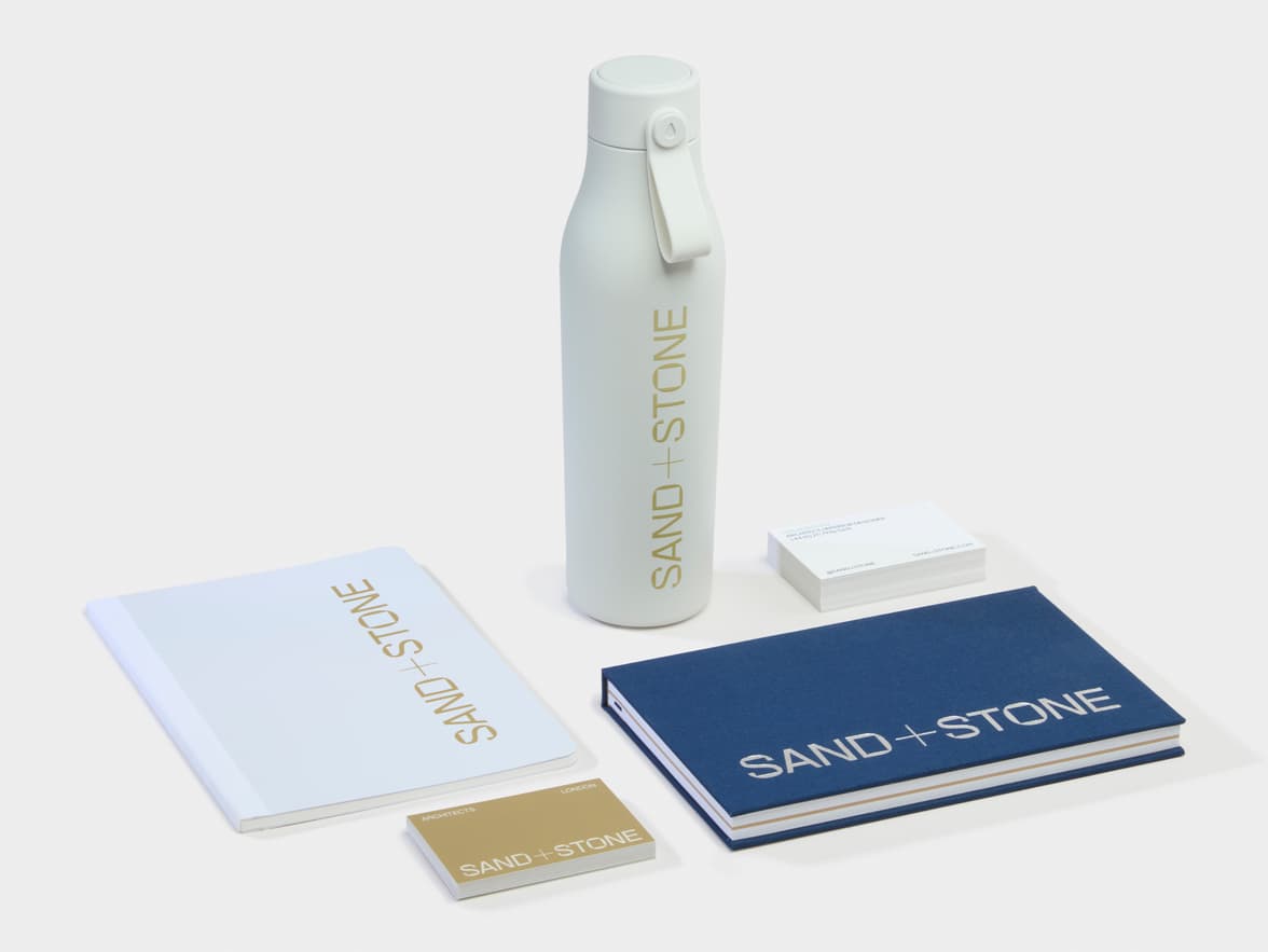 Branded Merchandise collection featuring a water bottle, business cards and two notebooks.