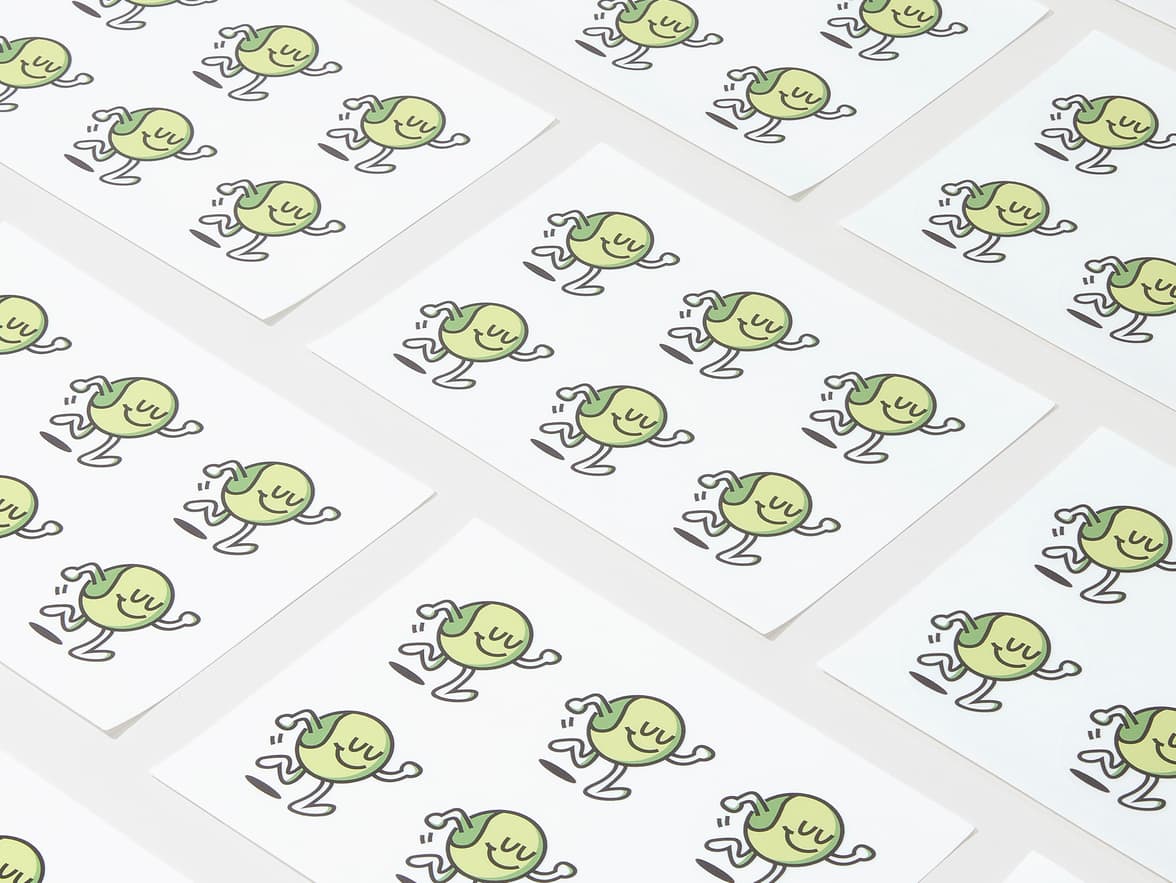 A collection of customized clear round stickers with a green cartoon character printed on them.