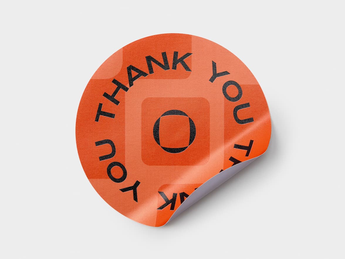 An orange customized round coated sticker.