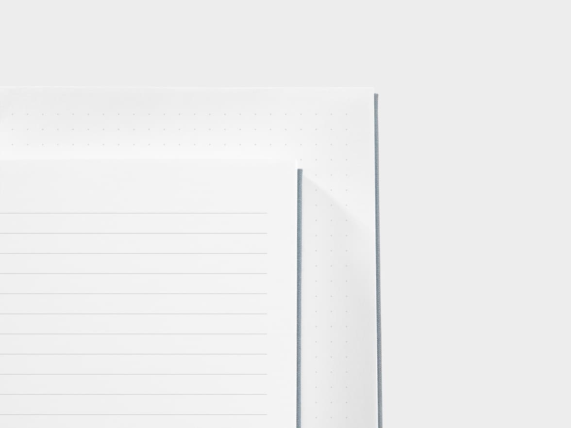 A close up of a dotted paper and a lined paper next to each other 