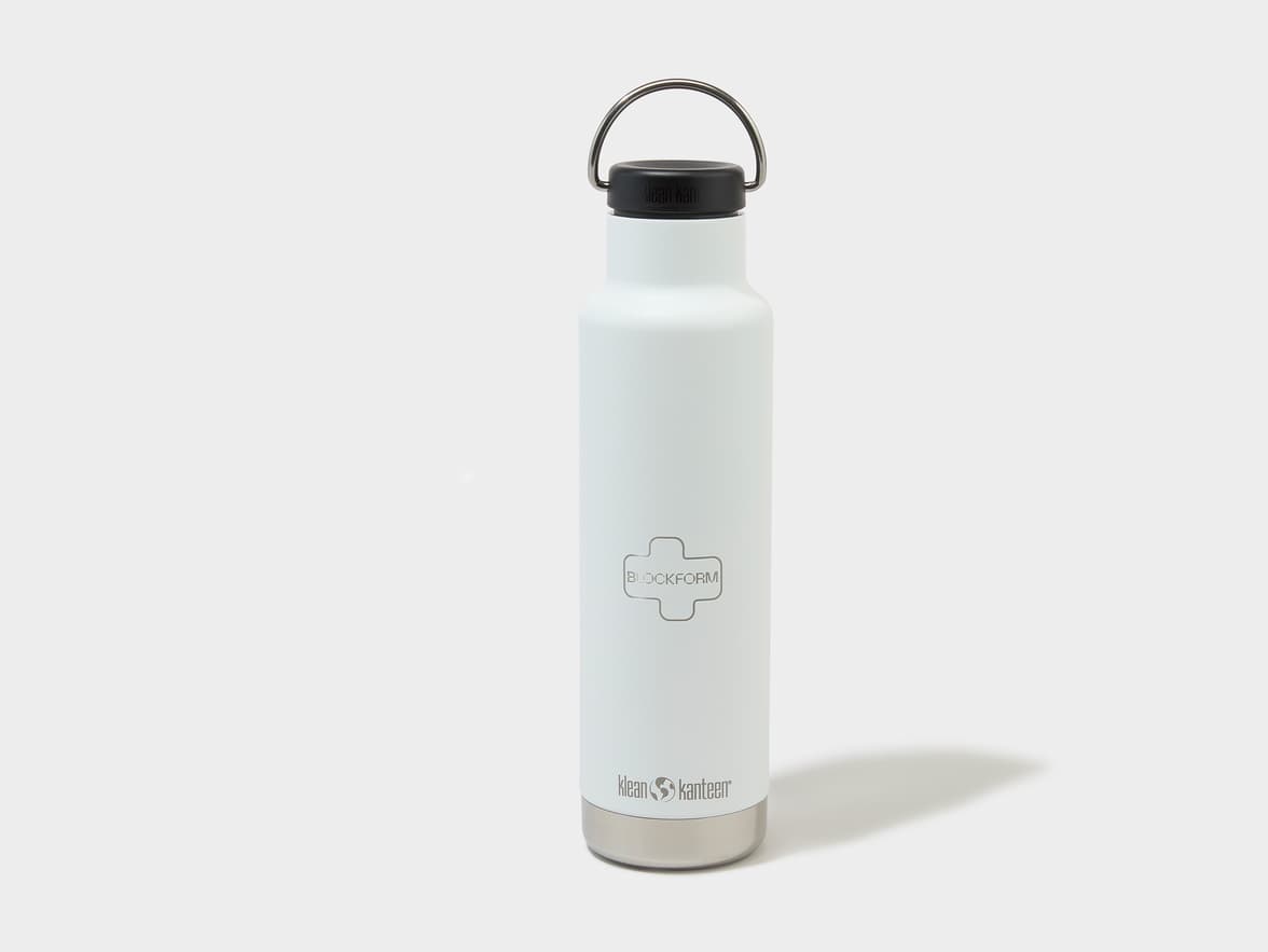 A white Klean Kanteen water bottle with a black cap, metal handle, and a "BLOCKFORM" logo on its body.