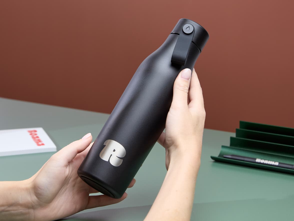 A person holding a custom black water bottle.