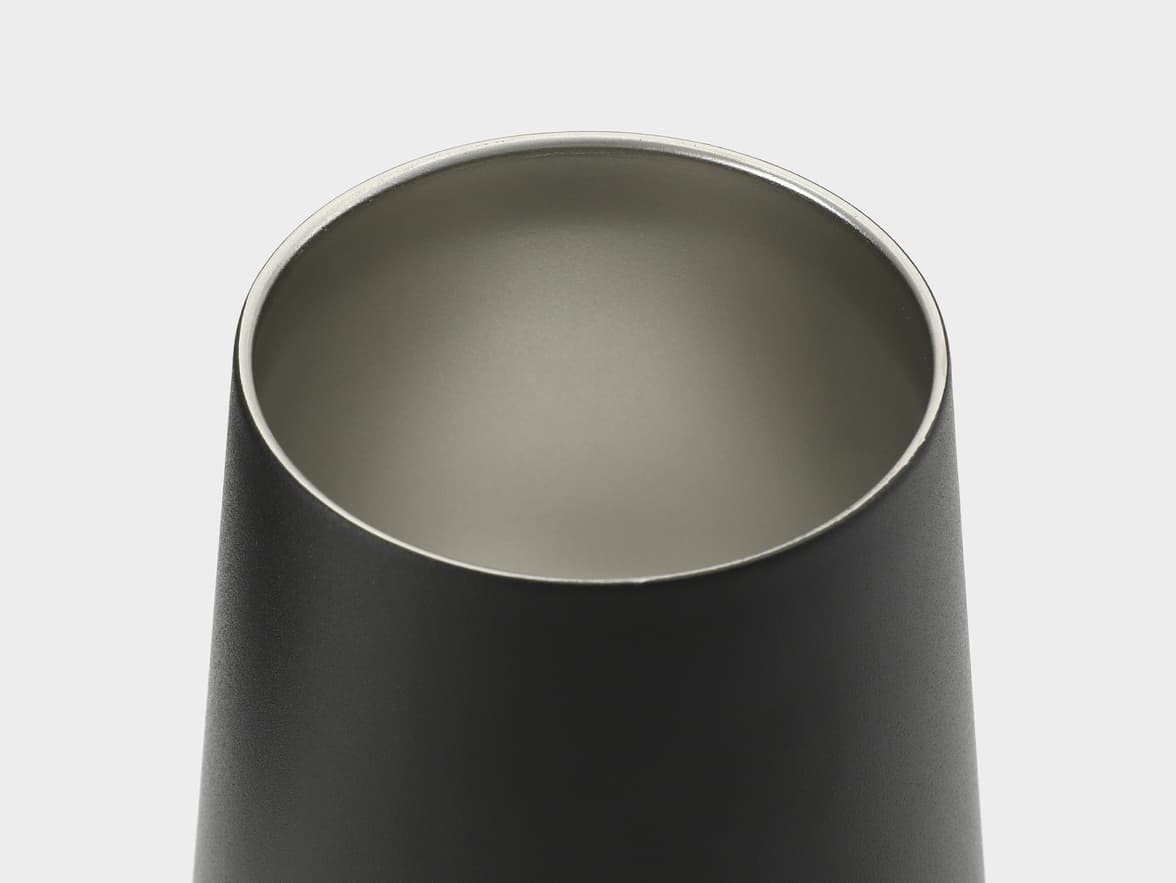 Close-up of the top of a black cylindrical object with a silver interior.