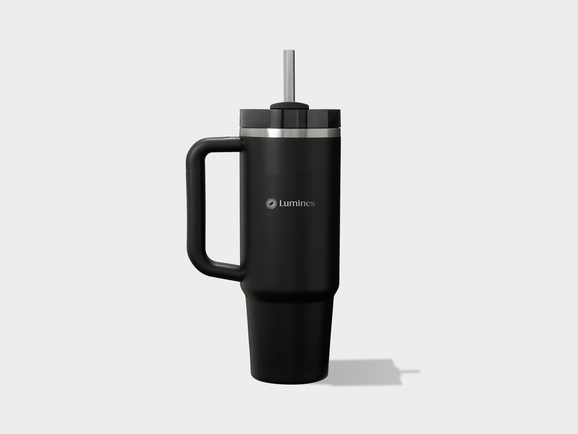 Black handled tumbler with metal straw and "Lumines" logo on a gray background.