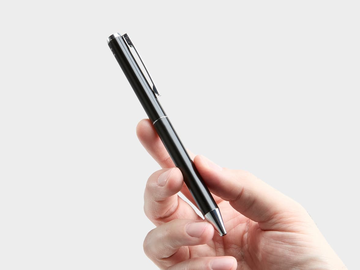 Hand holding a black S.T. Dupont pen.