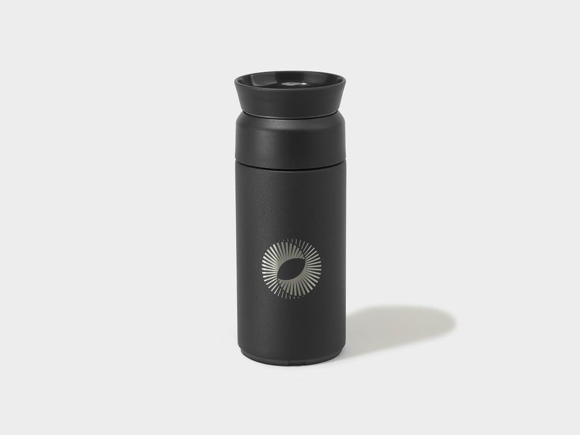 Black thermal flask with a silver circular sunburst logo.