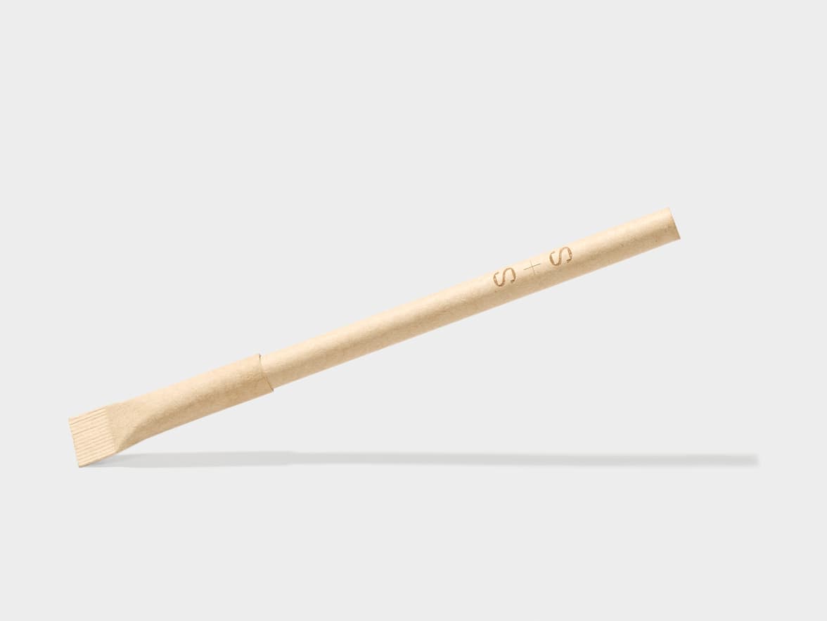 A brown paper straw with "S + S" branded on it, lying diagonally.