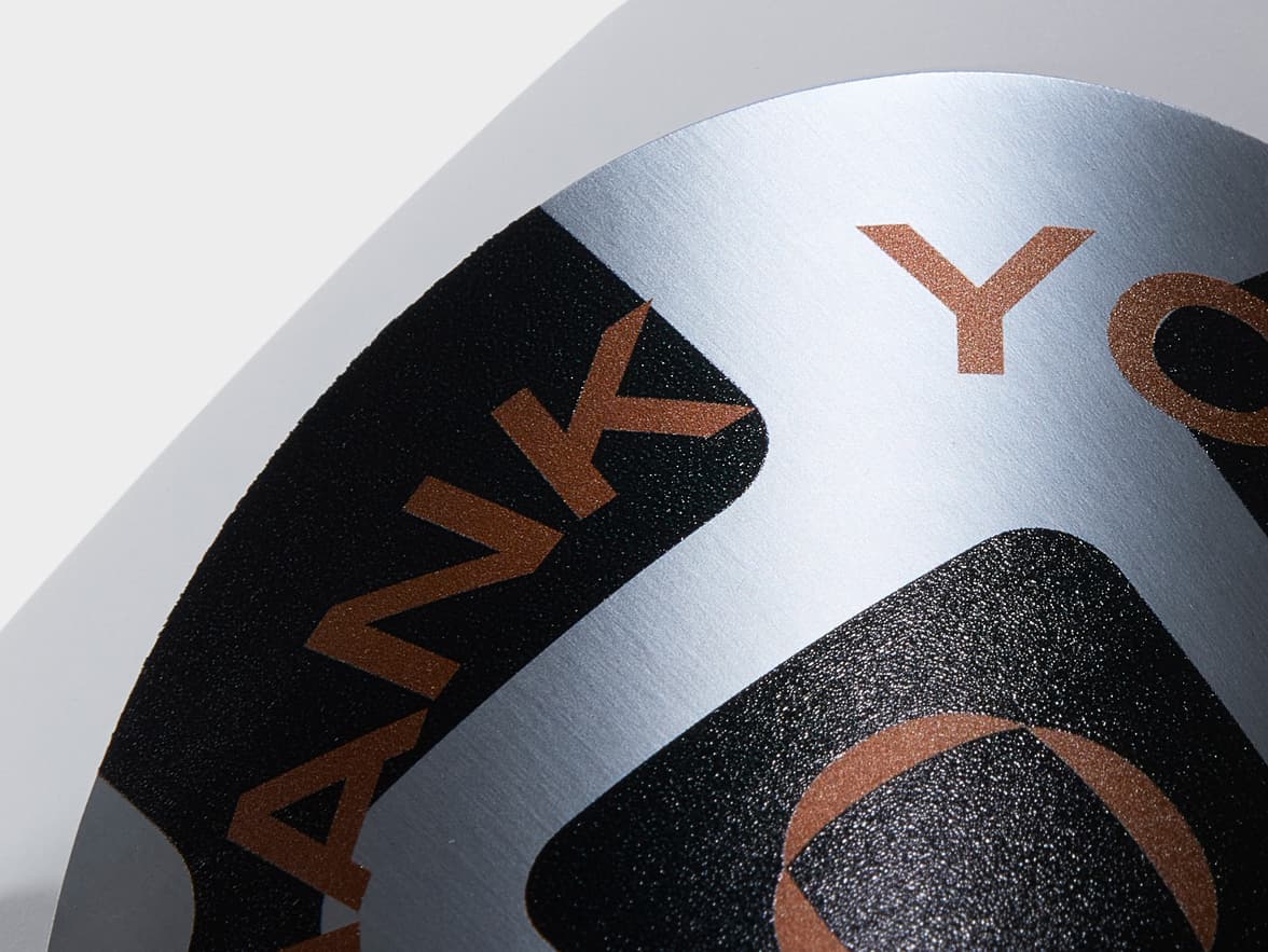 A detail image of a large round silver sticker.