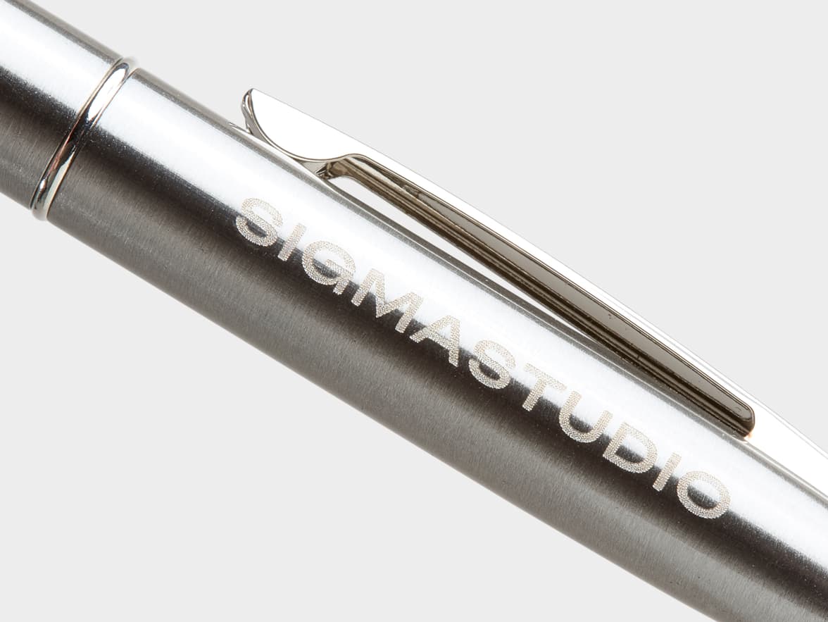 Silver metallic pen with "SIGMASTUDIO" engraved.