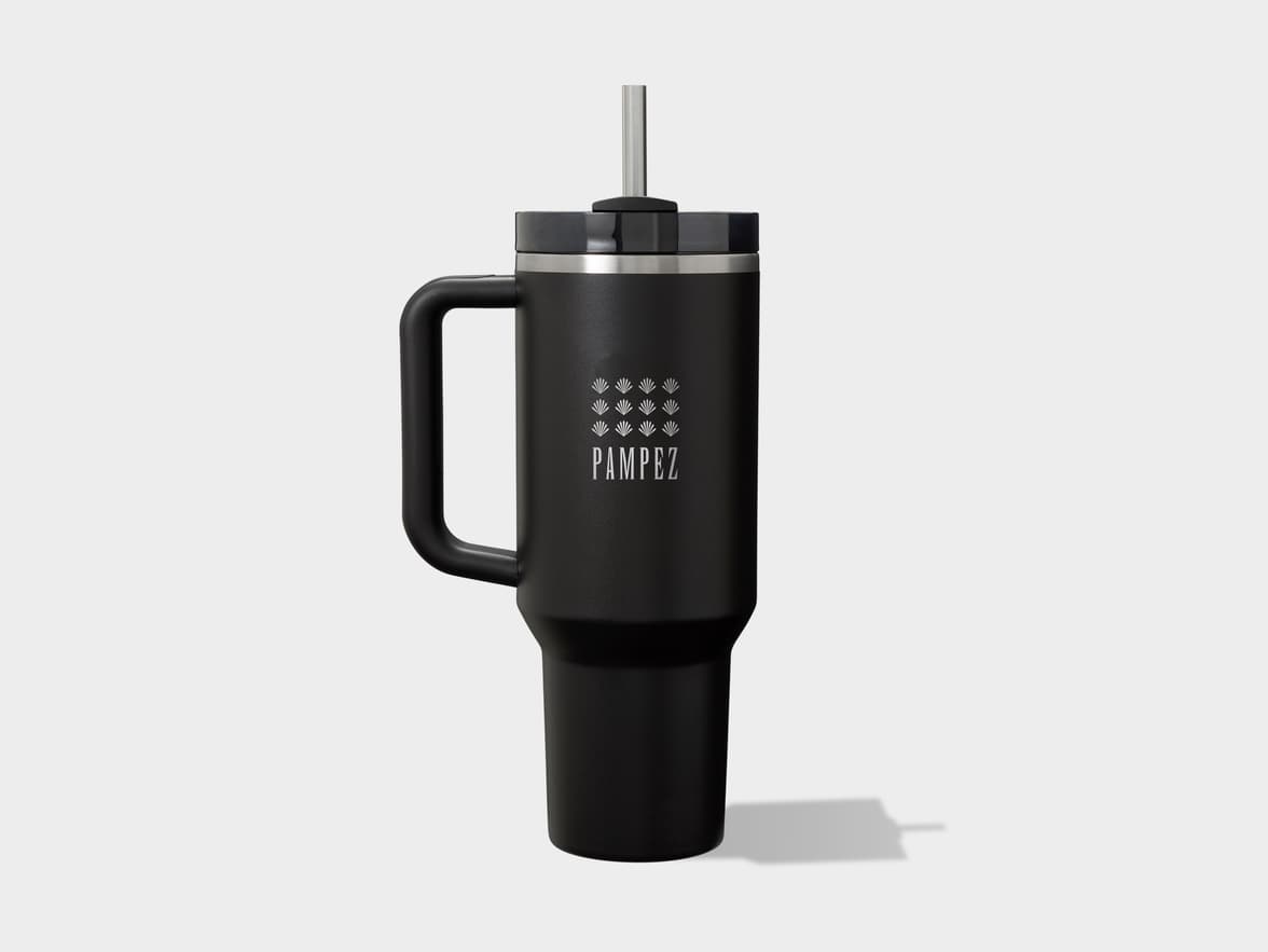 Black insulated tumbler with a handle, black lid, and metal straw, featuring a white "PAMPEZ" logo and stylized leaf symbols, on a light gray background.