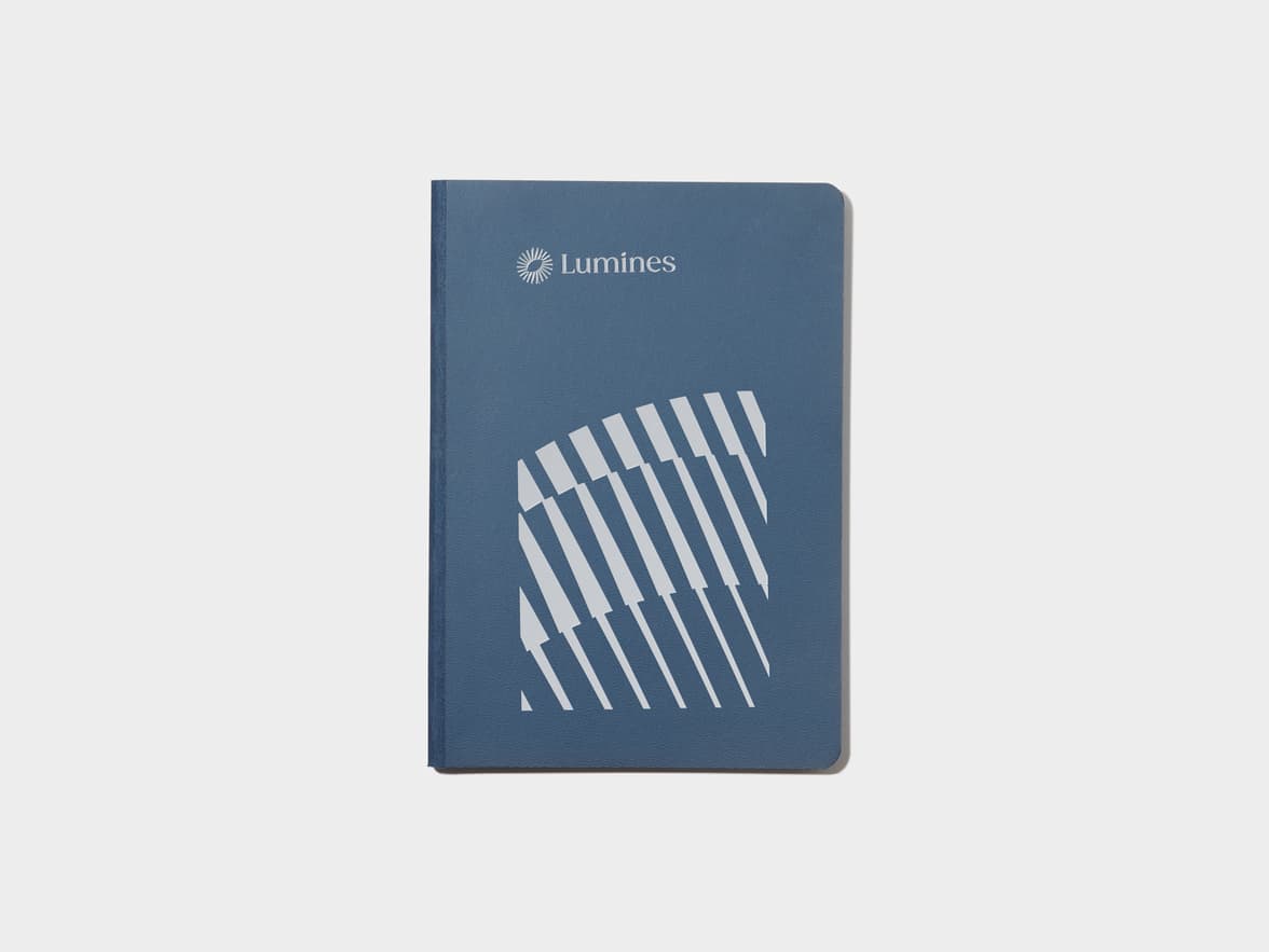 A midnight blue softcover notebook with silver foil customisation.