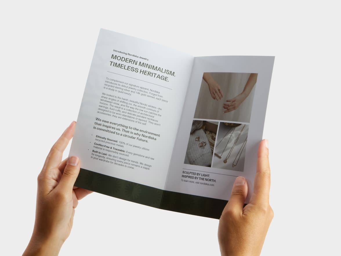 A pair of hands holding open a Bi-Fold Super Brochure.