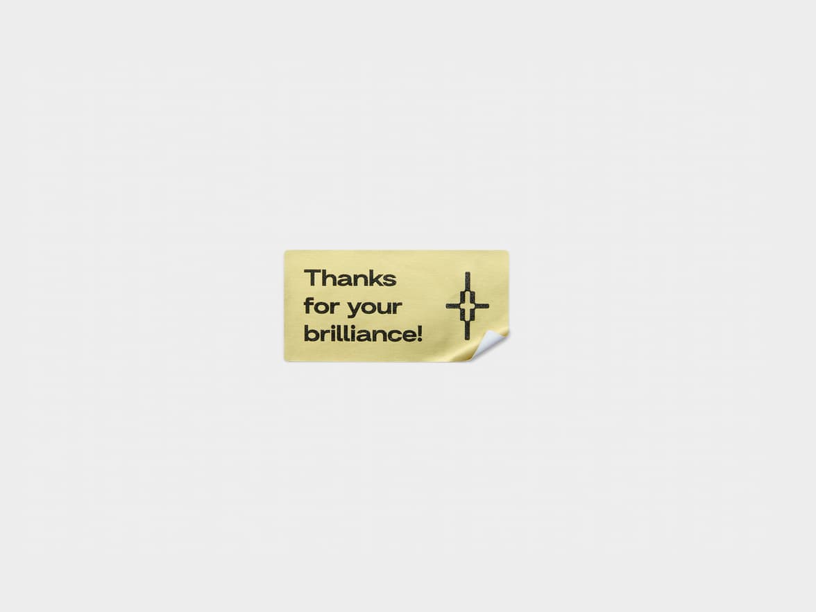 A gold metallic rectangular sticker with black customization.