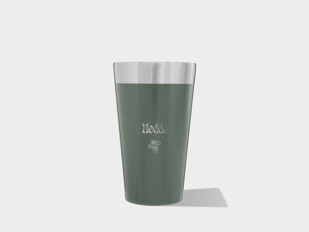 A dark green Meddo tumbler with a silver top and floral design, casting a shadow on a light gray background.