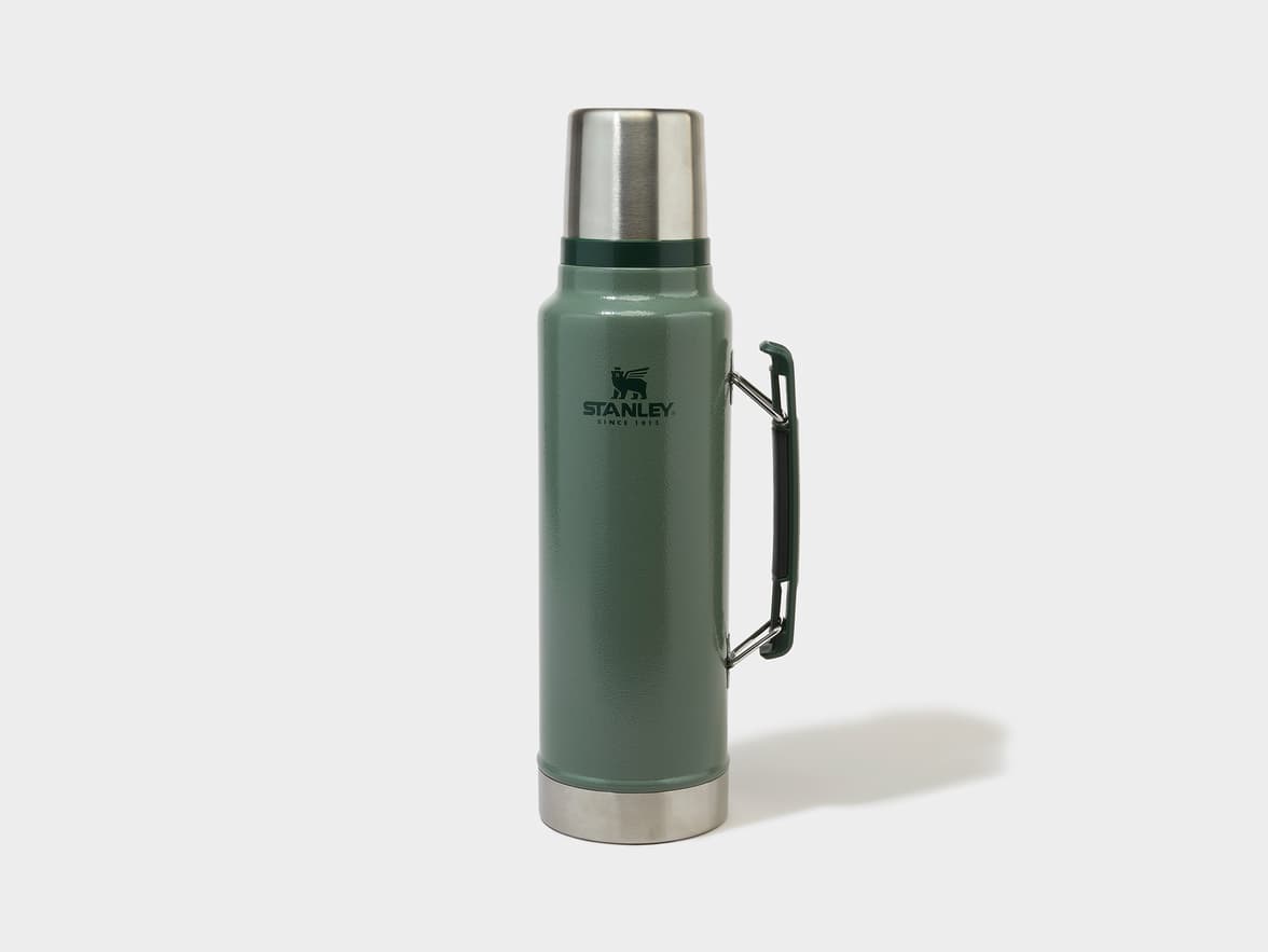 Green Stanley thermos with a silver cap and base, and a black handle, featuring the "STANLEY SINCE 1913" logo.