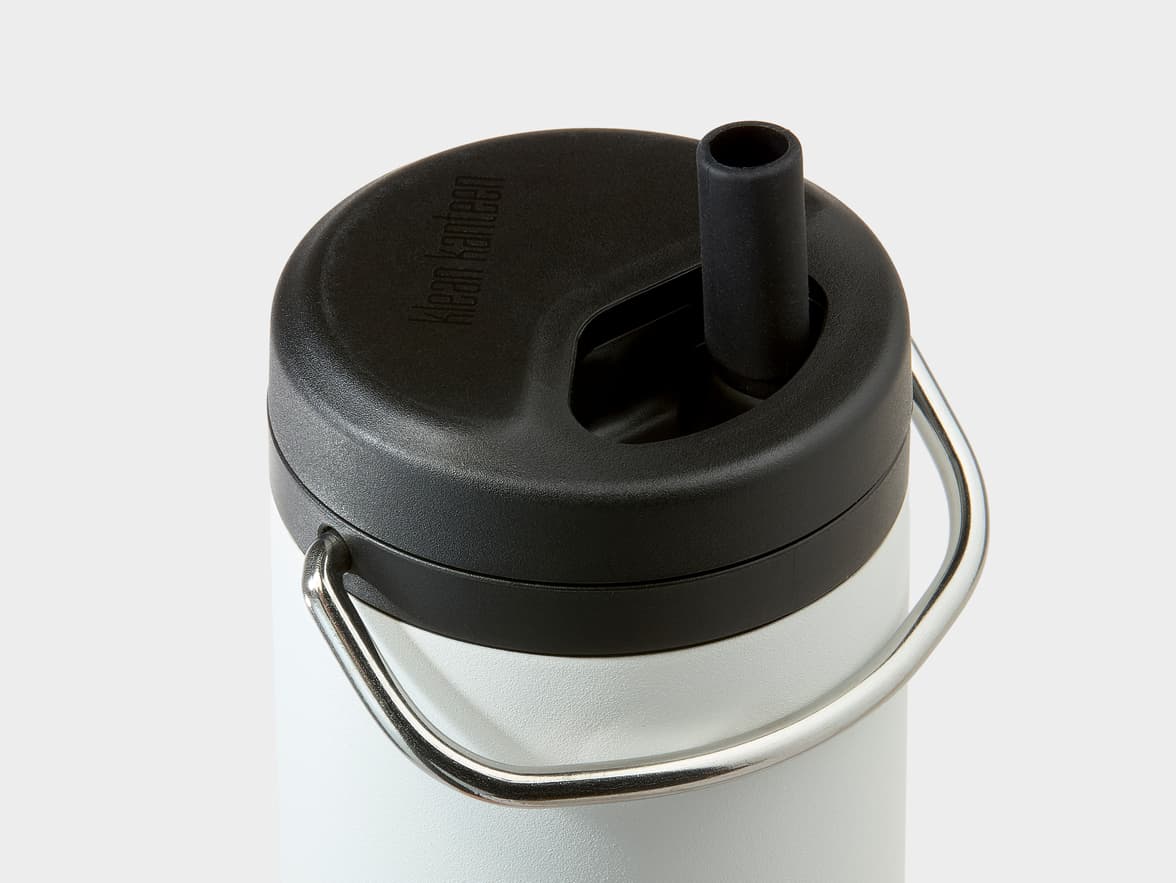 Top of a white Klean Kanteen bottle with a black lid featuring a built-in straw and a metal carry handle.