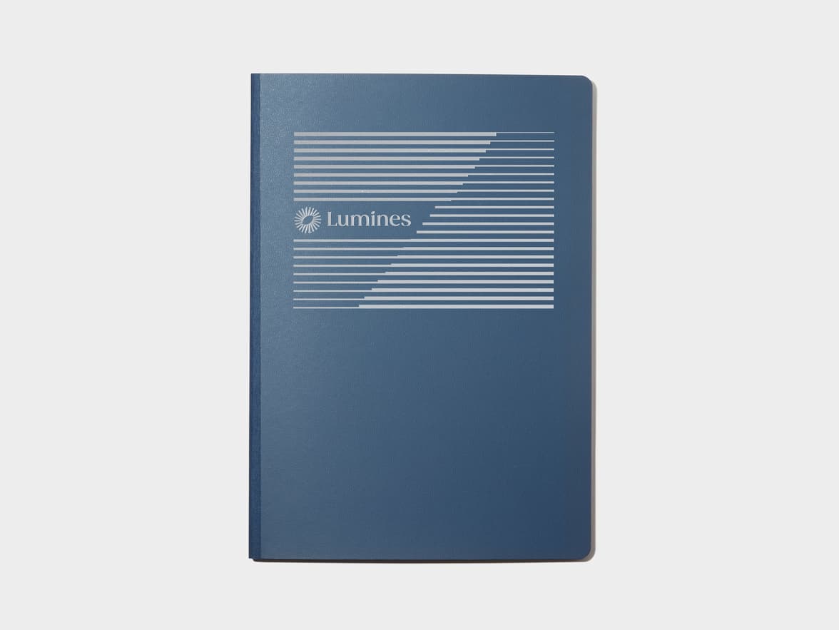 A large midnight blue softcover notebook with silver foil customisation.
